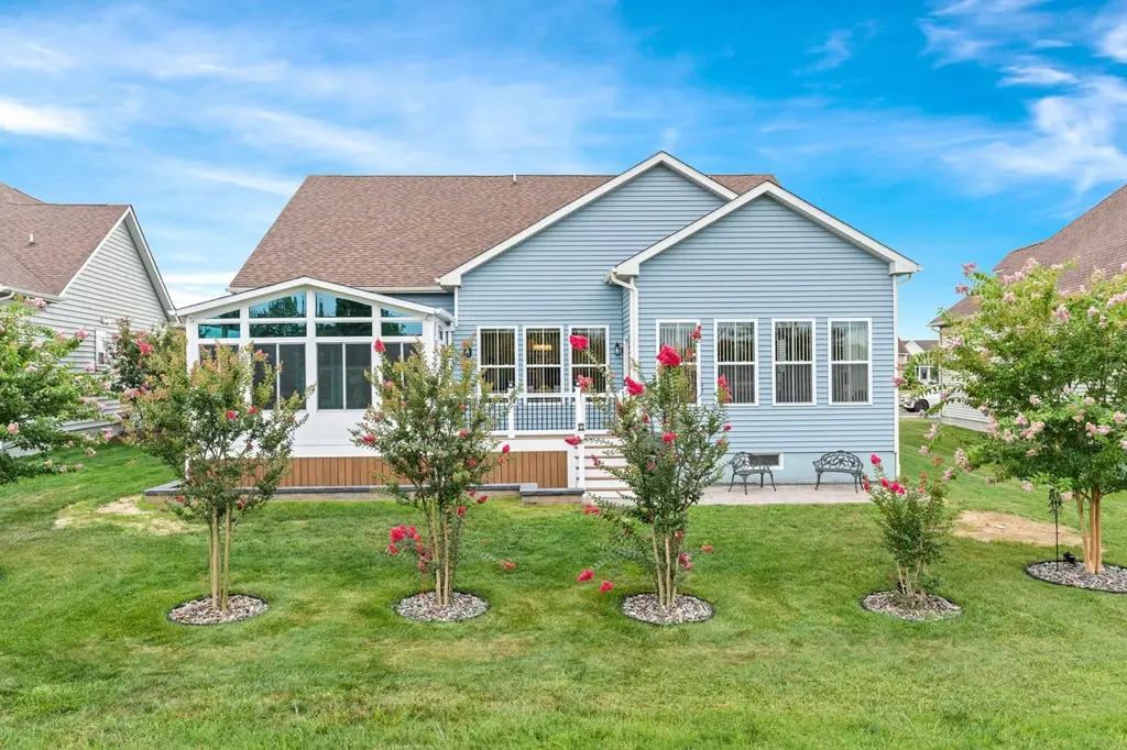 About Us at Calahan Bath, Kitchen and Sunrooms. Image of a blue sided house with a new Calahan sunroom installed. Calahan is also your top roofing contractor! Make the right decision with Calahan for your roof replacement.